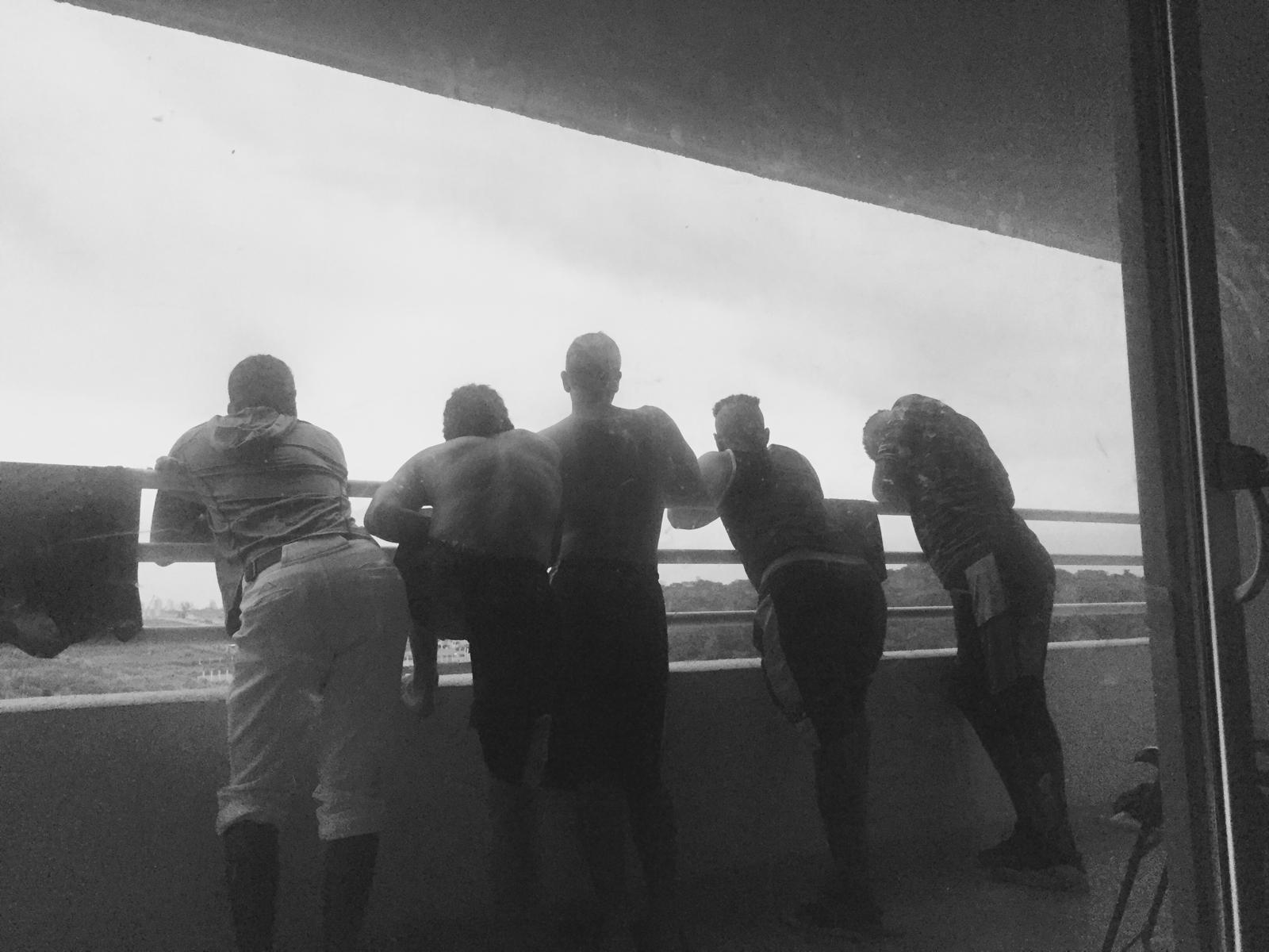 Players at a balcony rail watching a game